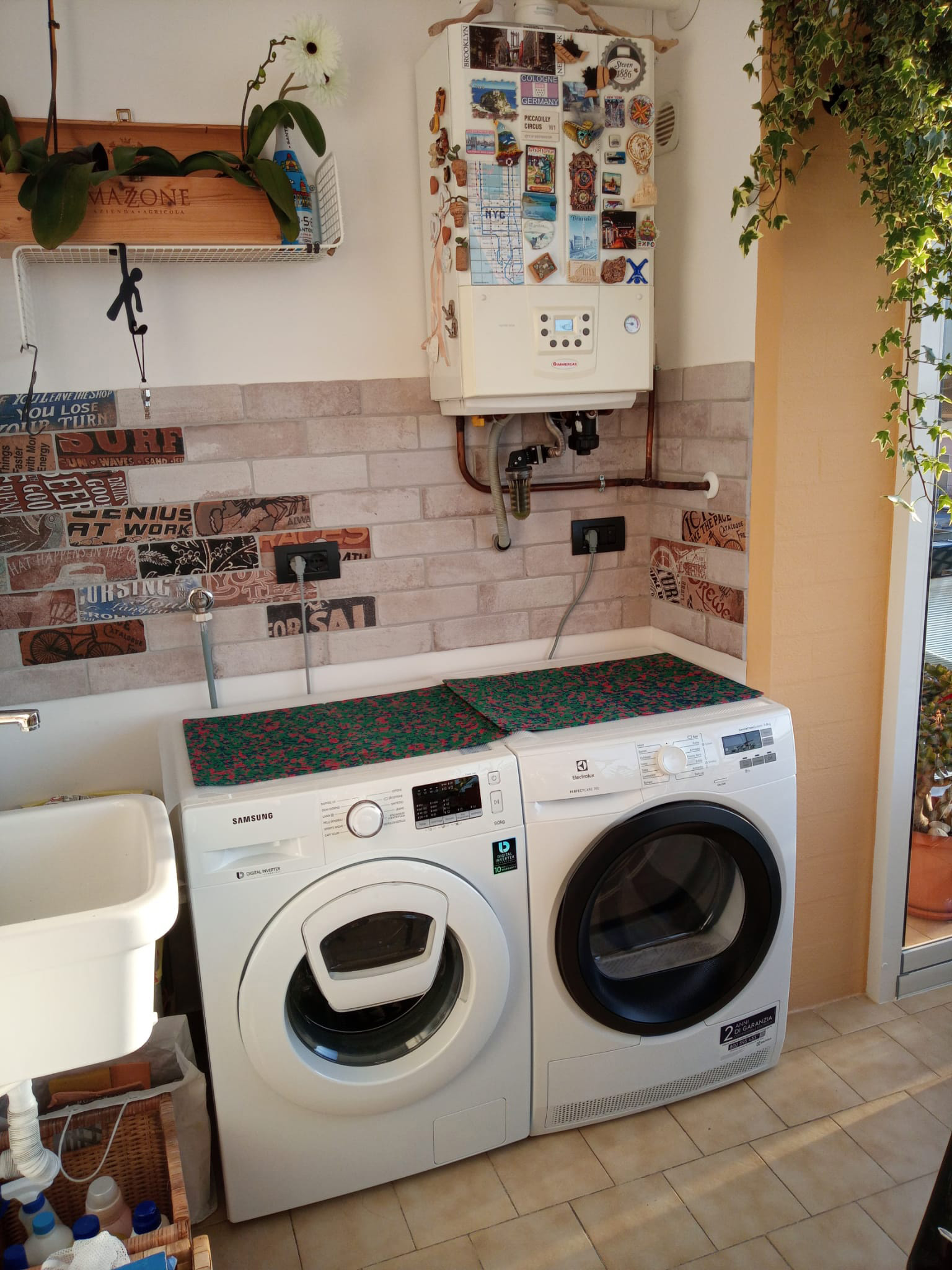 Lavanderia prima dell'intervento con lavatrice e lavello a vista — progetto Mercuri Design a Ruvo di Puglia