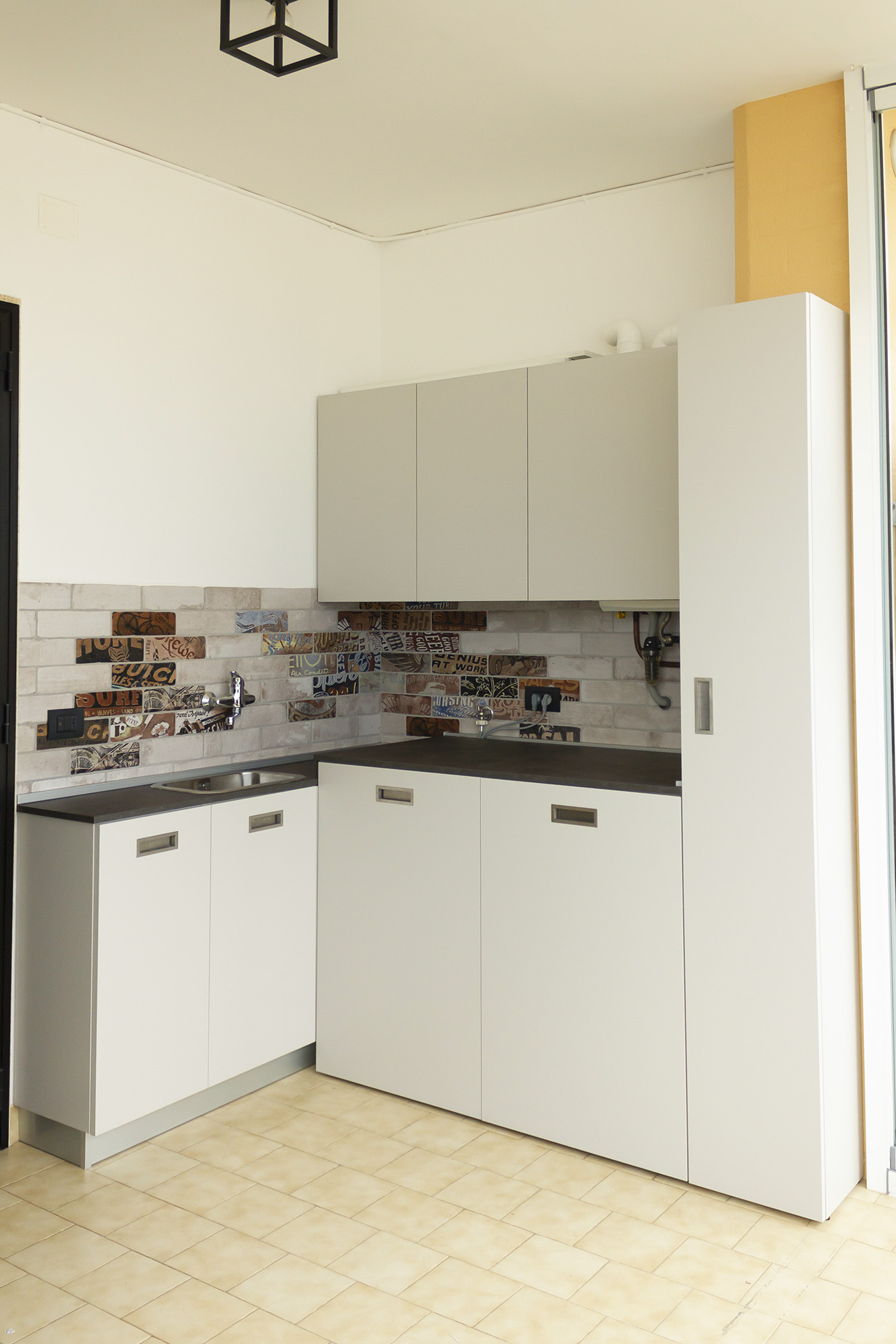 Lavanderia su misura completata con ante chiuse che nascondono lavatrice e asciugatrice — Mercuri Design